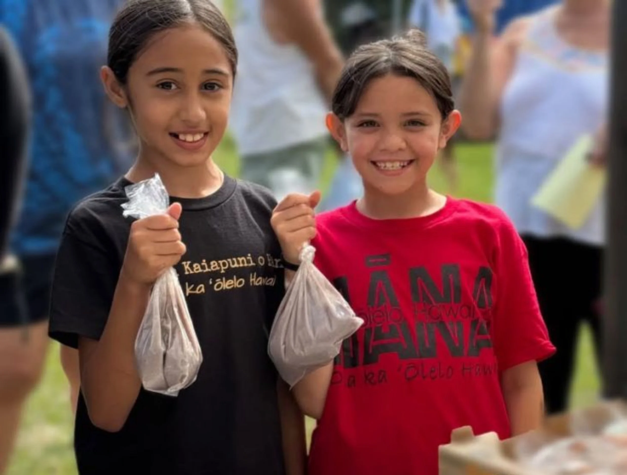 two girls holding bags of poi