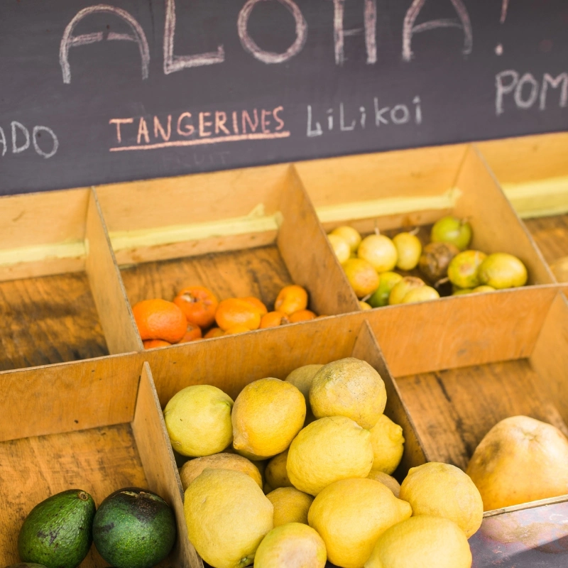 Fruits Avocados, tangerines and lilikois on display at a farm stand.
